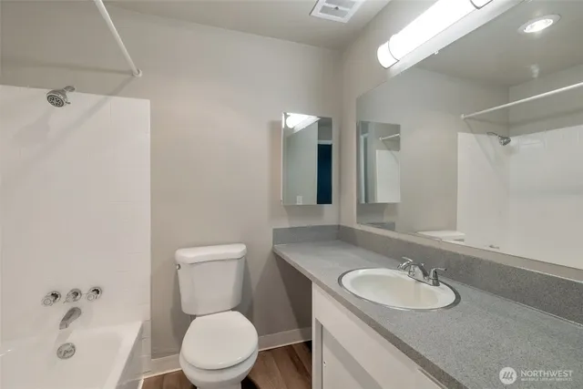 a bathroom with a sink a toilet and a mirror