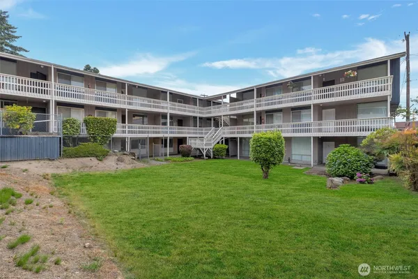a front view of a house with a yard and potted plants