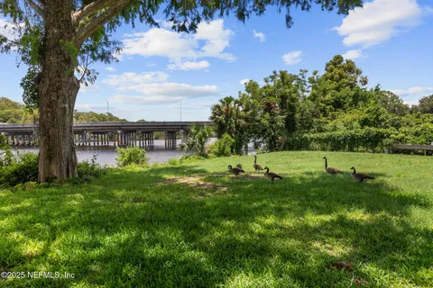 an aerial view of residential houses with outdoor space and lake view