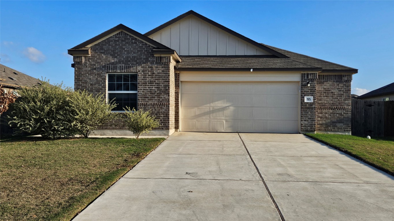 Ranch-style house with brick siding, concrete driveway, board and batten siding, and an attached garage
