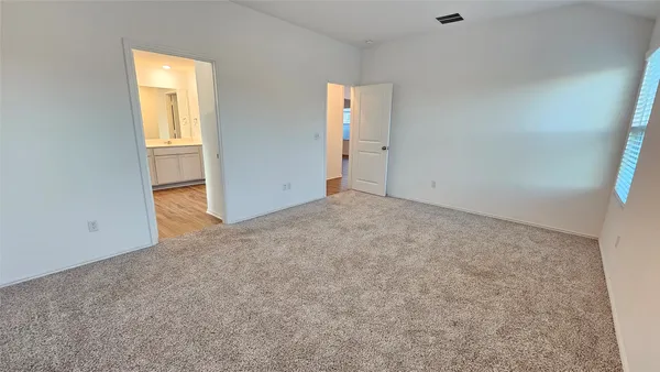 a kitchen with stainless steel appliances granite countertop white cabinets a refrigerator a sink a stove a microwave and wooden floors