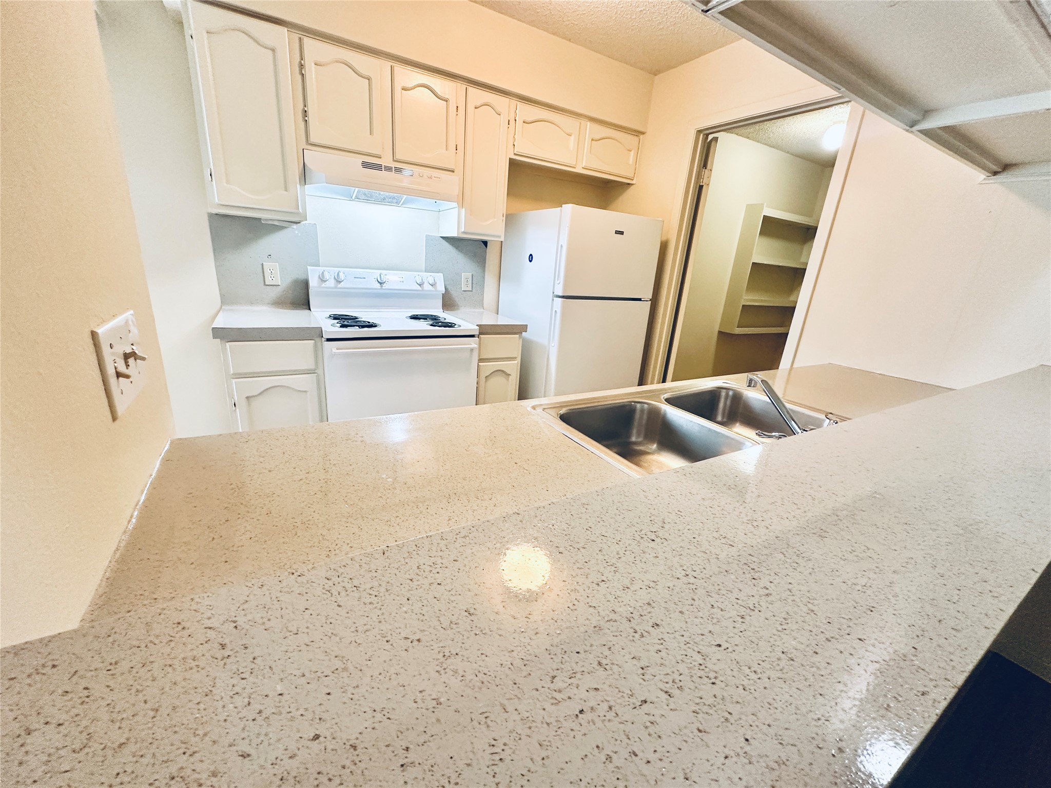 12504 Tree Line Drive, Unit B Austin, TX 78729 - Photo 6 of 22 Kitchen featuring white appliances and a textured ceiling