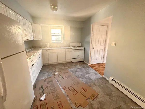 a kitchen with white cabinets and white appliances