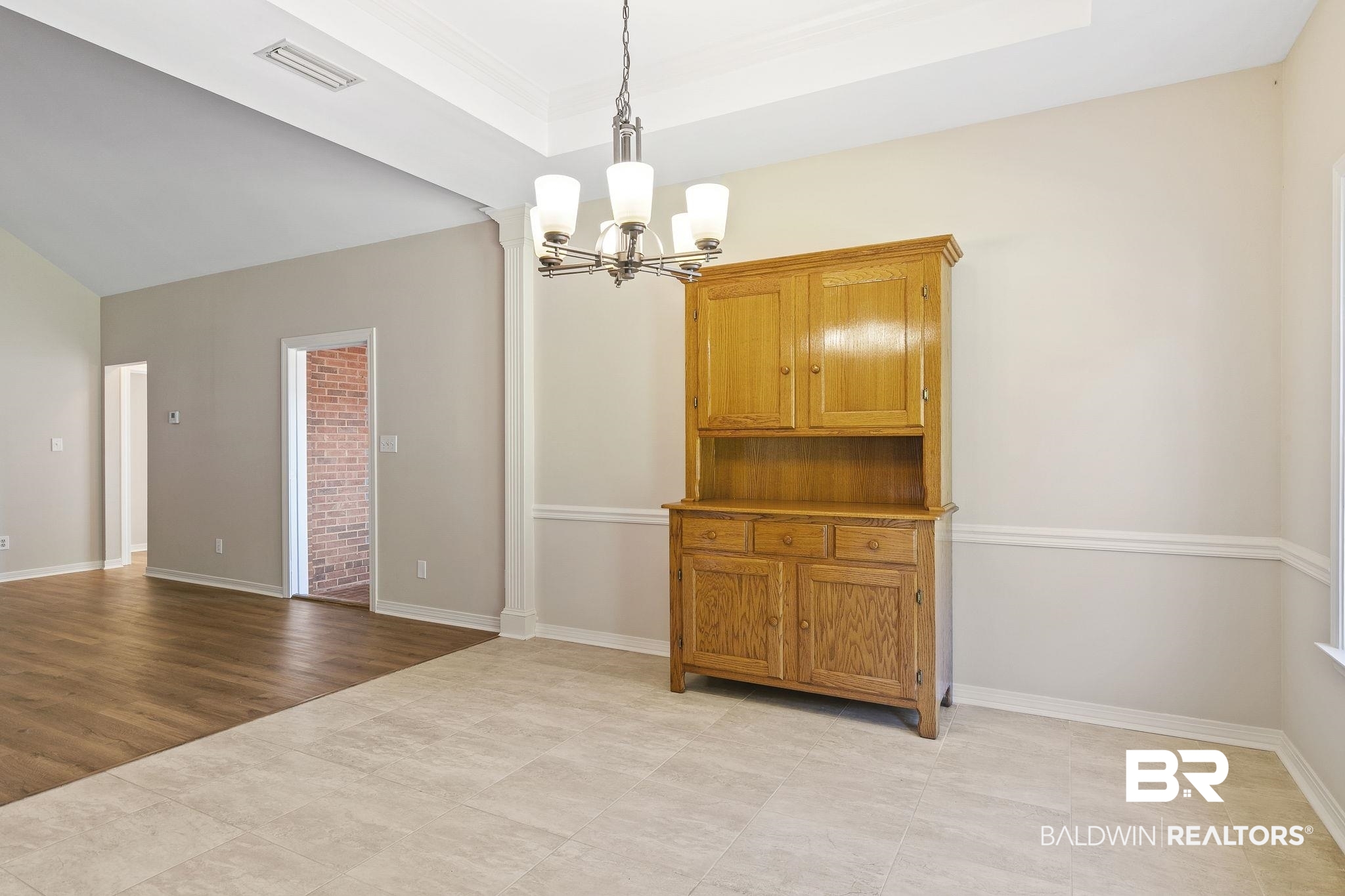 9631 Bay Meadows Avenue Fairhope, AL 36532 - Photo 16 of 49 Dining area with light tile, ornamental molding, and an inviting chandelier