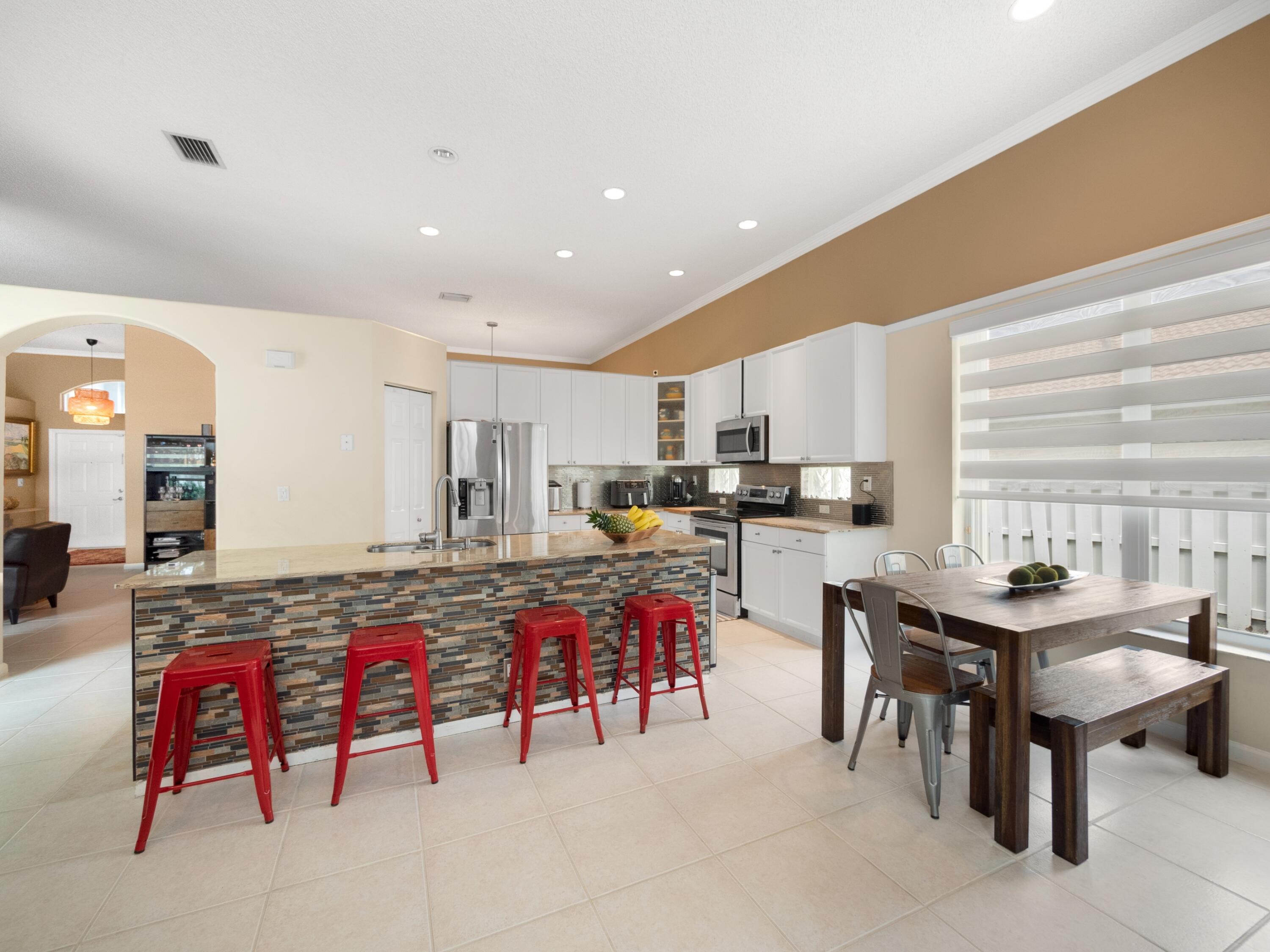 a living room with stainless steel appliances kitchen island granite countertop furniture and a dining table