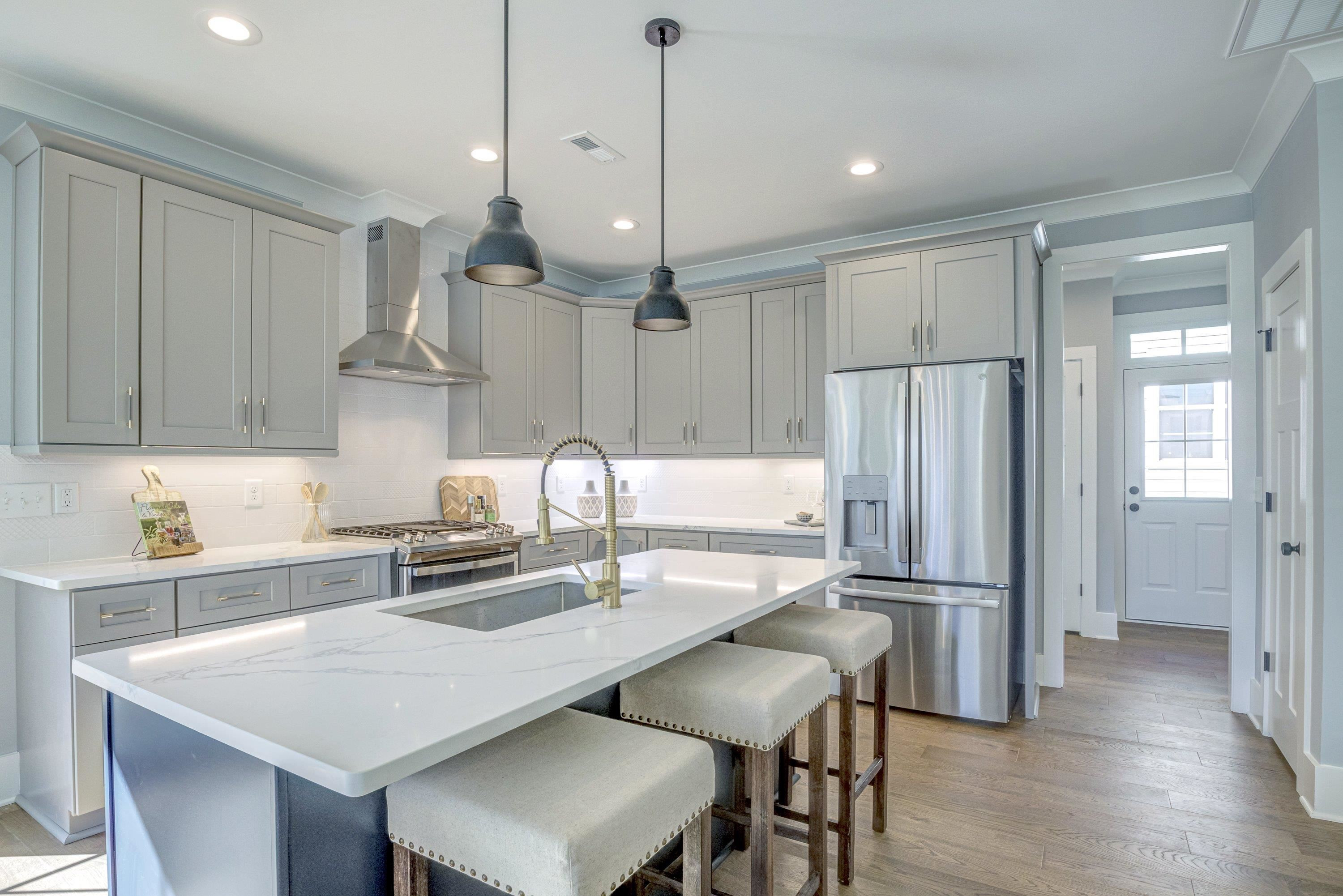 210 Knowles Street Raleigh, NC 27603 - Photo 17 of 65 a kitchen with stainless steel appliances a dining table chairs sink and cabinets