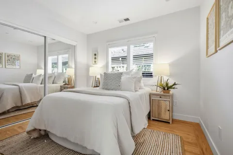 a spacious bedroom with a bed and wooden floor