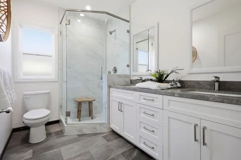 a bathroom with a granite countertop sink a toilet and shower