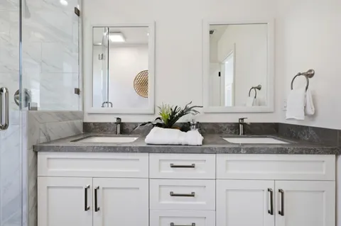 a bathroom with double sink and a mirror