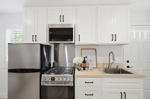 a kitchen with appliances a sink and cabinets