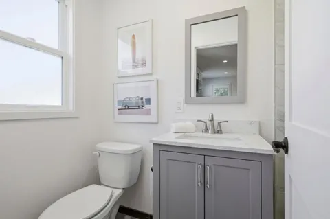a bathroom with a toilet a sink and mirror