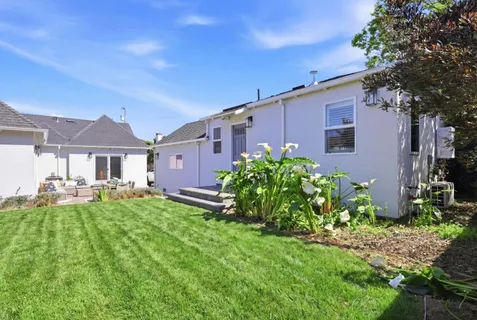 a front view of house with a garden