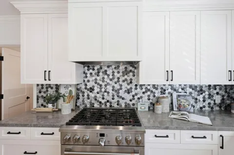 a kitchen with granite countertop a stove and cabinets