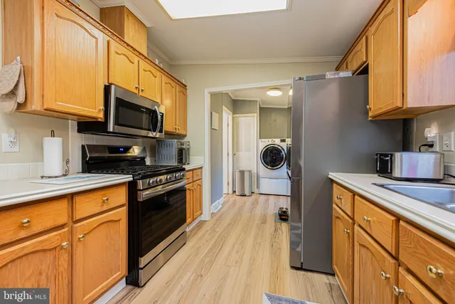 a kitchen with stainless steel appliances granite countertop a refrigerator a stove top oven a sink and dishwasher