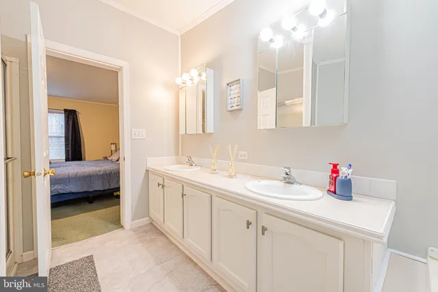 a en suite bathroom with a double vanity sink and a mirror