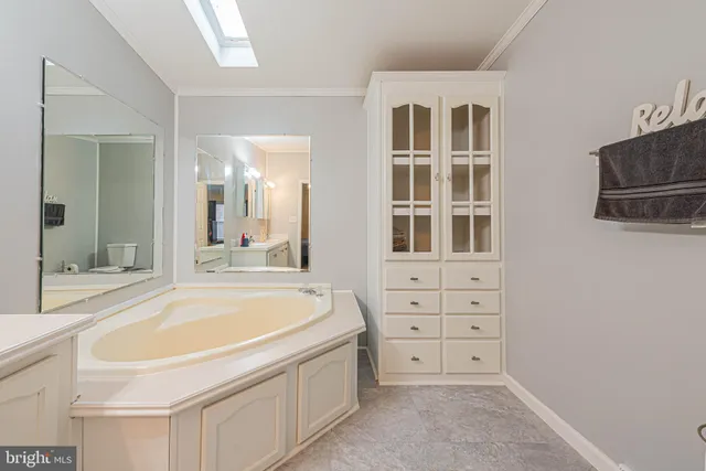 a bathroom with a tub sink and mirror