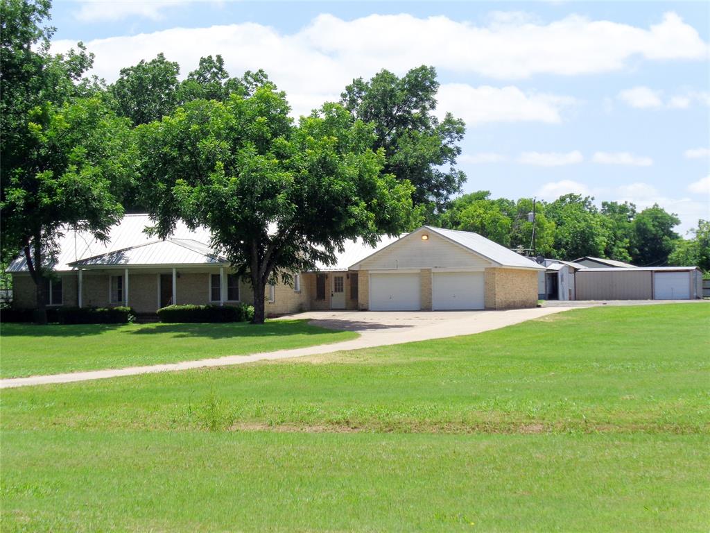 1717 Pipeline Road Cleburne, TX 76033 - Photo 20 of 33 Spacious property featuring a light brick exterior, a covered front porch with white columns, a metal roof, and an attached two-car garage