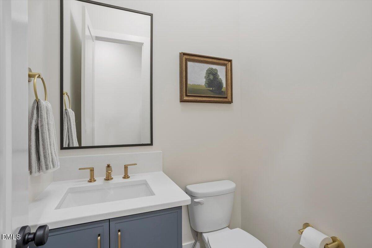 811 Maple Berry Lane, Unit 101 Raleigh, NC 27607 - Photo 21 of 45 a bathroom with a toilet sink vanity and mirror