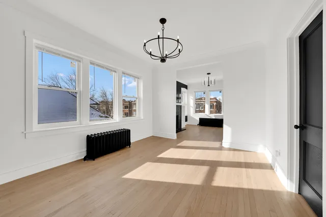 a view of empty room with kitchen and windows