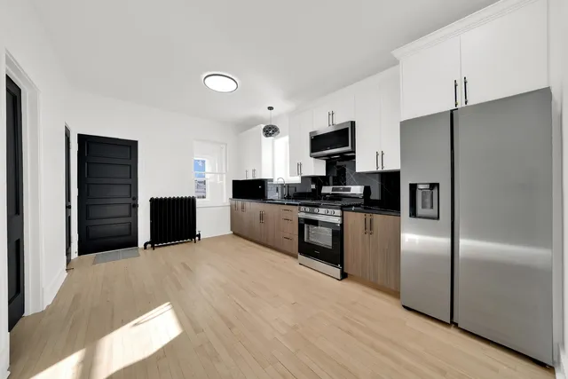 a kitchen with granite countertop a refrigerator a stove a sink and a microwave