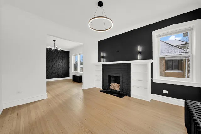 a view of an empty room with a window and fireplace
