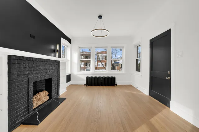 a view of an empty room with a fireplace and a window