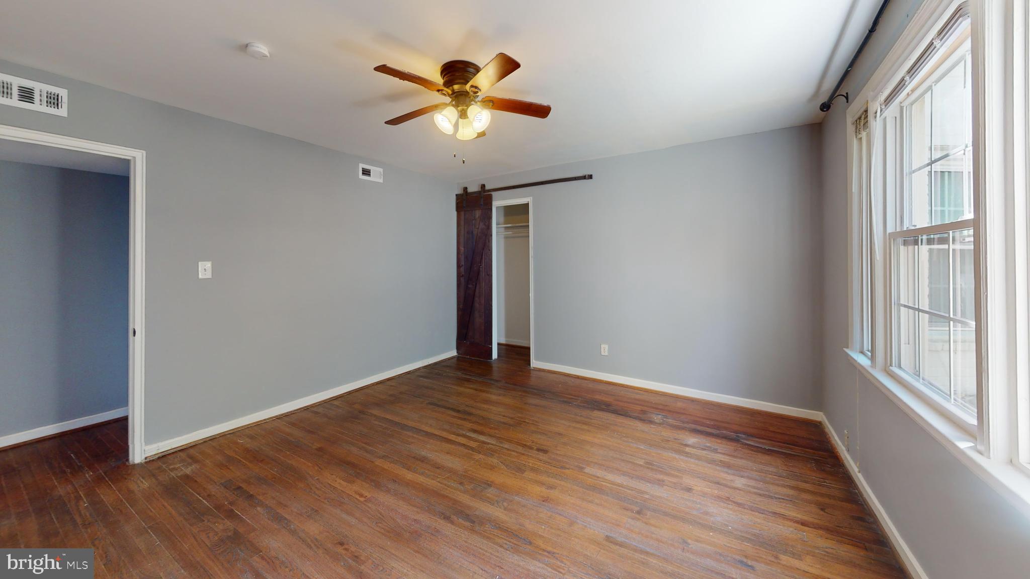 2203 Washington Avenue, Unit 102 Silver Spring, MD 20910 - Photo 11 of 13 an empty room with wooden floor and chandelier fan