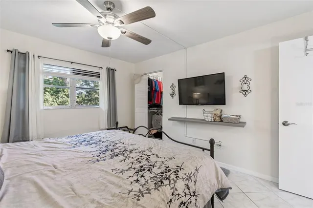 a bedroom with bed tv and window