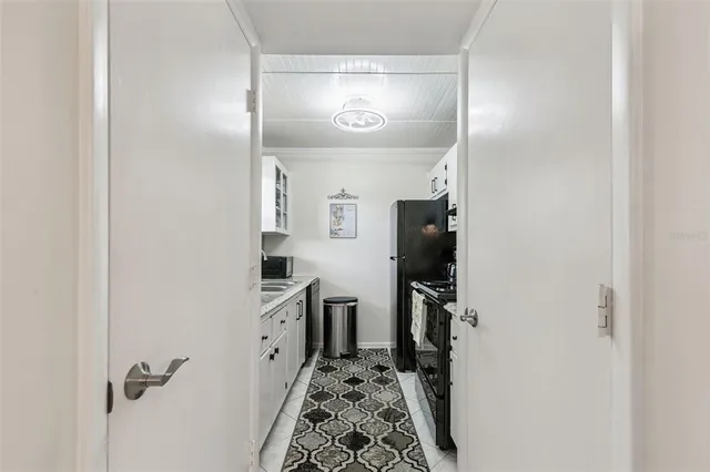 a hallway with white cabinets and wooden floor