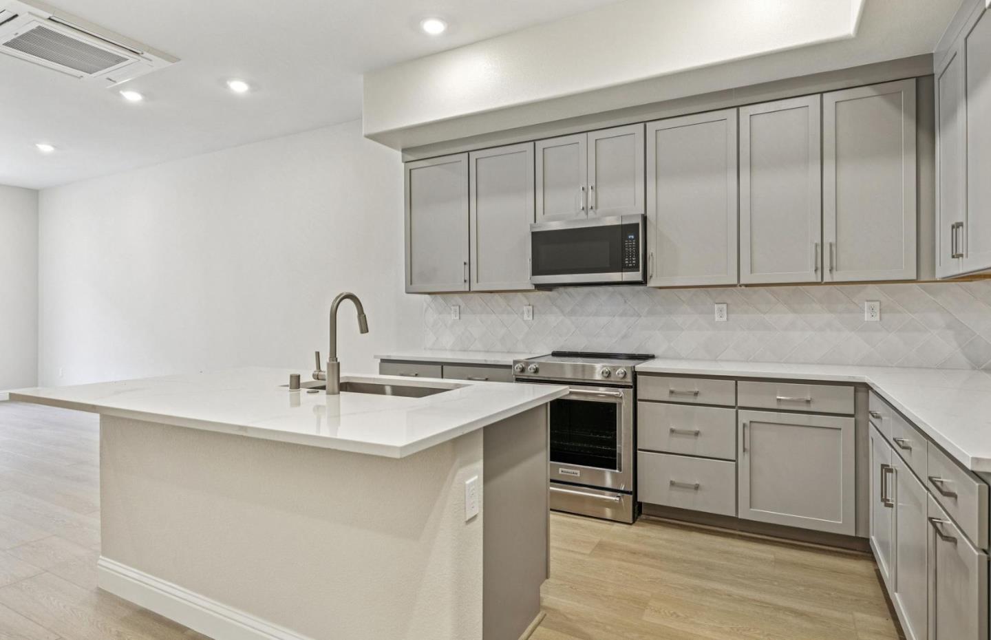 2417 Willow Way San Mateo, CA 94403 - Photo 15 of 34 a kitchen with stainless steel appliances granite countertop a sink and a stove top oven with wooden floor