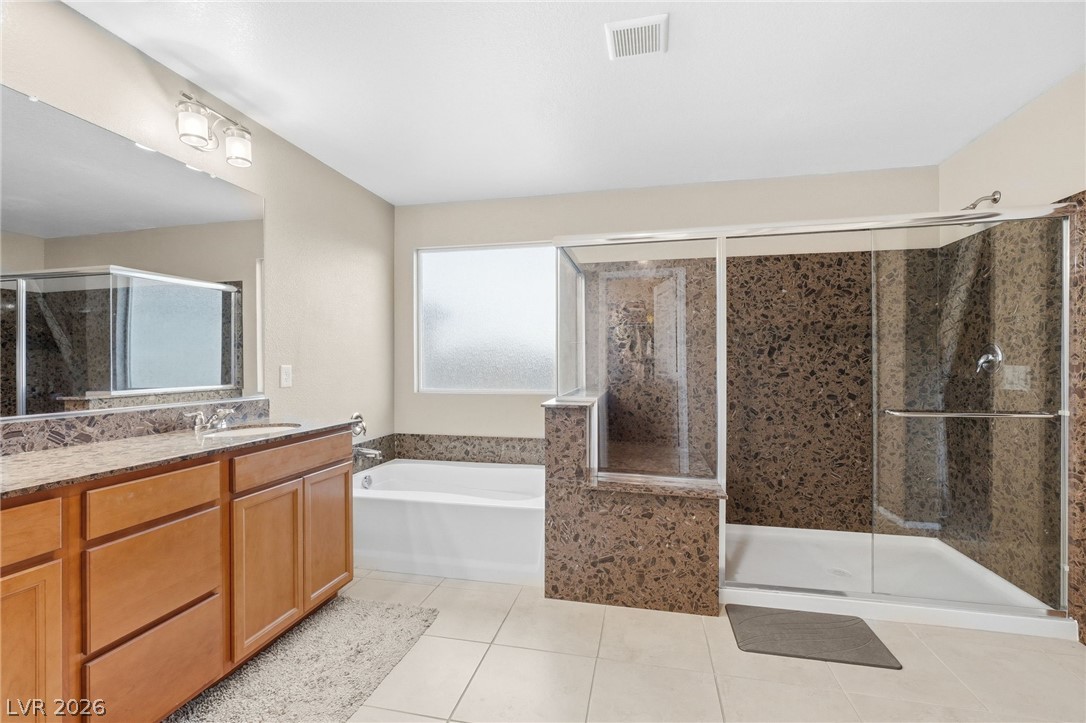 150 Fulgora Street Henderson, NV 89074 - Photo 47 of 92 Bathroom featuring vanity, a bath, a stall shower, and light tile patterned flooring