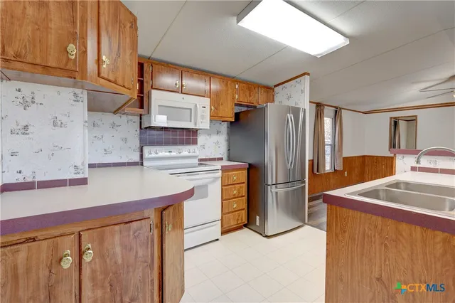 a view of kitchen with stainless steel appliances granite countertop lots of counter top space