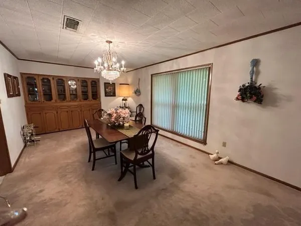 a view of a dining room with furniture and chandelier