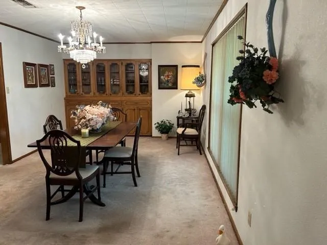 a view of a dining room with furniture and chandelier