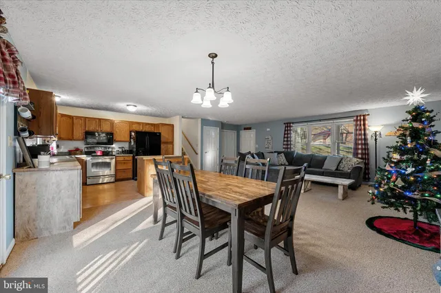 a kitchen with stainless steel appliances granite countertop a refrigerator a sink dishwasher a stove with wooden cabinets and floor