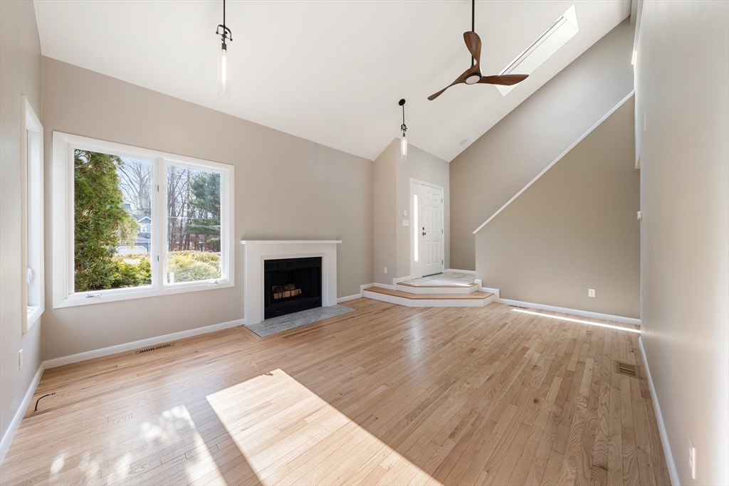5 Lanes End Natick, MA 01760 - Photo 5 of 27 a view of empty room with wooden floor and fireplace