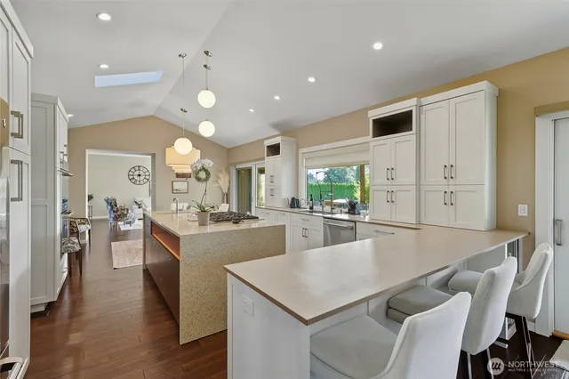 a large kitchen with kitchen island a stove a sink a dining table and chairs