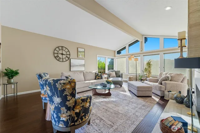 a living room with furniture floor to ceiling window and wooden floor