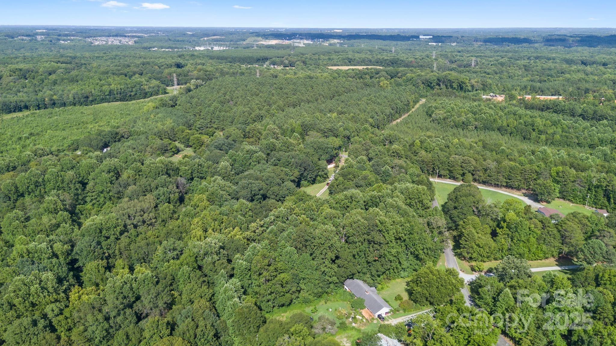 1902 Rock Hollar Road Stanley, NC 28164 - Photo 23 of 27 a view of a lush green forest with trees and some houses