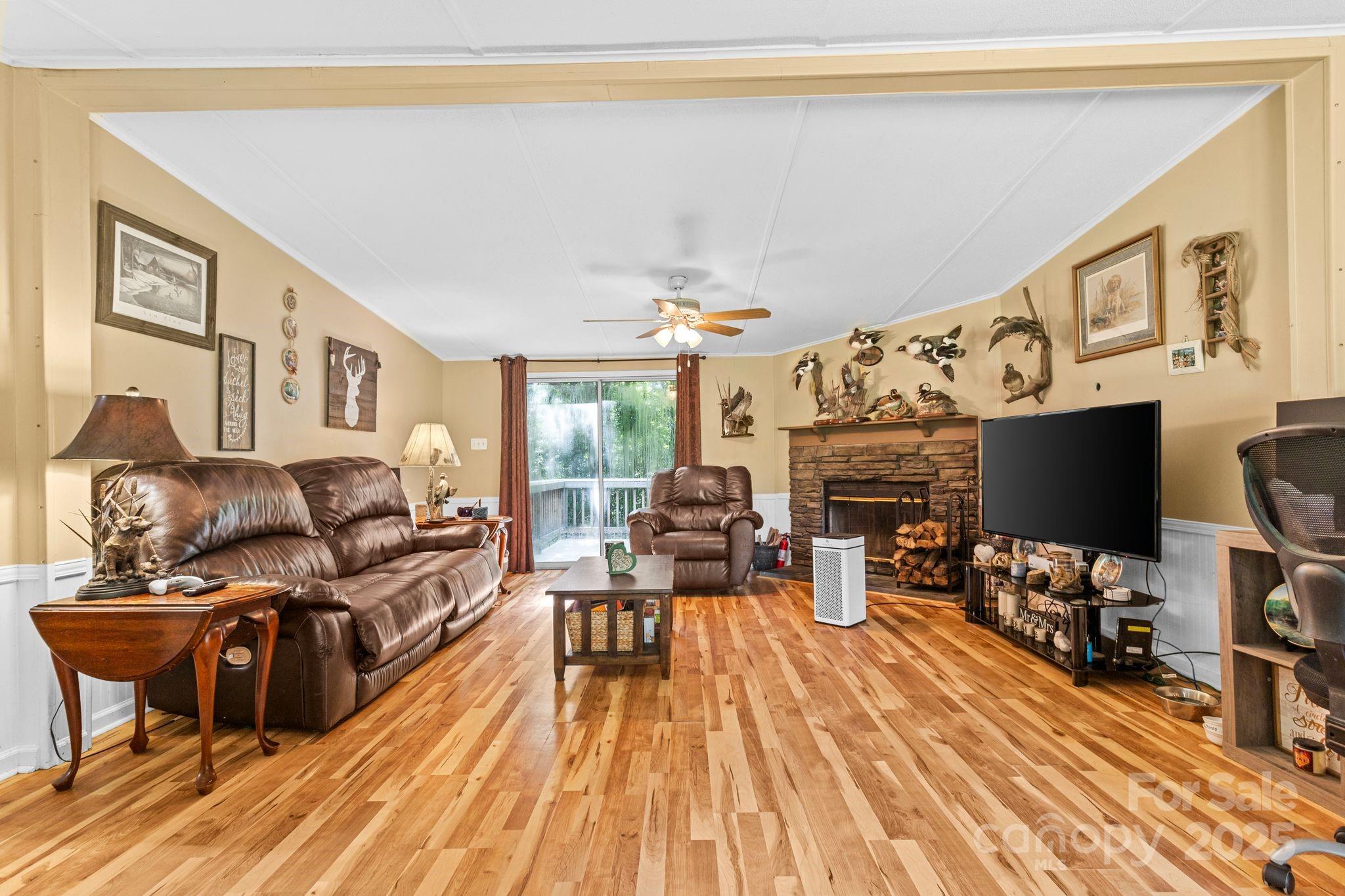 1902 Rock Hollar Road Stanley, NC 28164 - Photo 7 of 27 a living room with furniture a flat screen tv and a floor to ceiling window
