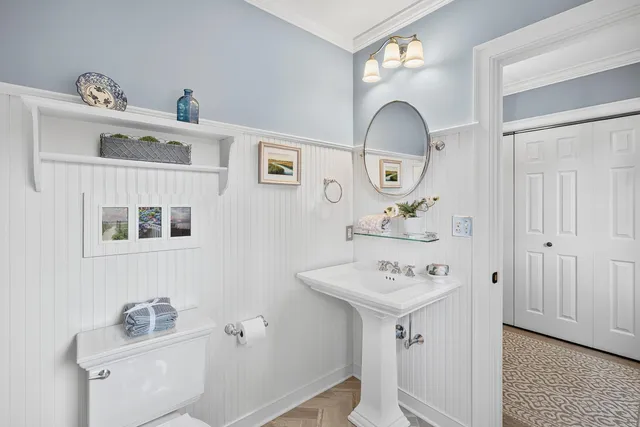 a bath room with a sink a potted plant and a window