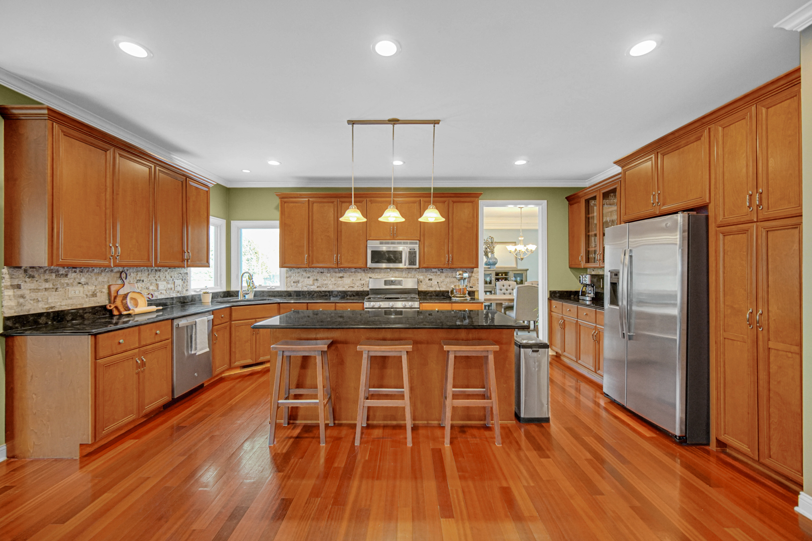 25216 Round Barn Road Plainfield, IL 60585 - Photo 12 of 31 a kitchen with stainless steel appliances granite countertop wooden floor a refrigerator a sink and wooden cabinets