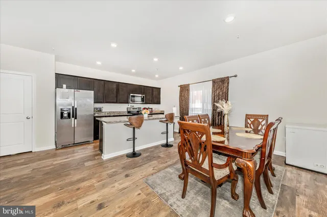 a dining room with furniture and kitchen view
