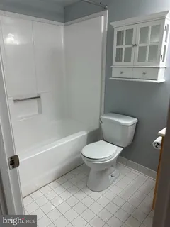 a white toilet sitting next to a bath tub