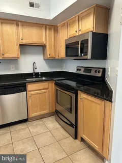 a kitchen with cabinets stainless steel appliances and a window