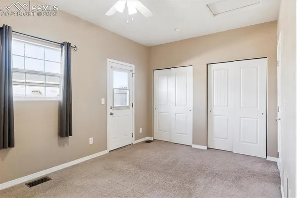 a view of an empty room with window and closet area
