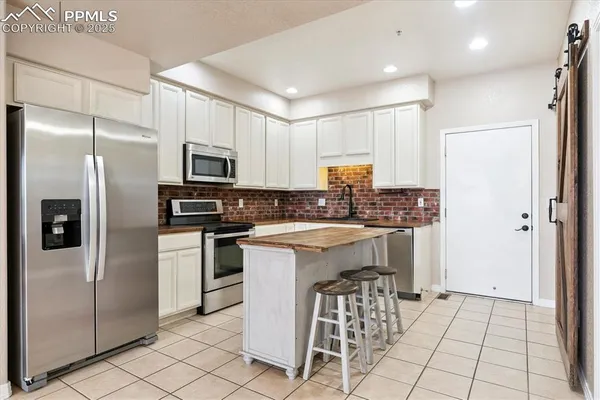 a kitchen with a refrigerator a sink and a stove top oven
