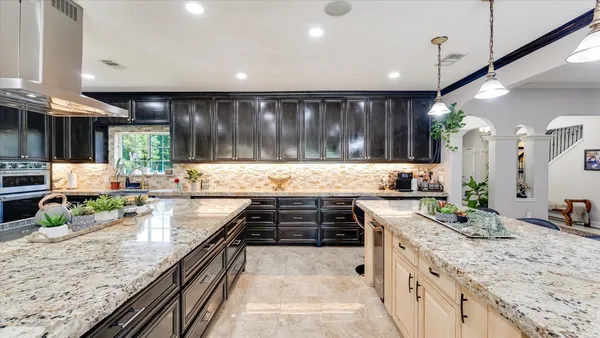 a kitchen with stainless steel appliances kitchen island granite countertop a refrigerator