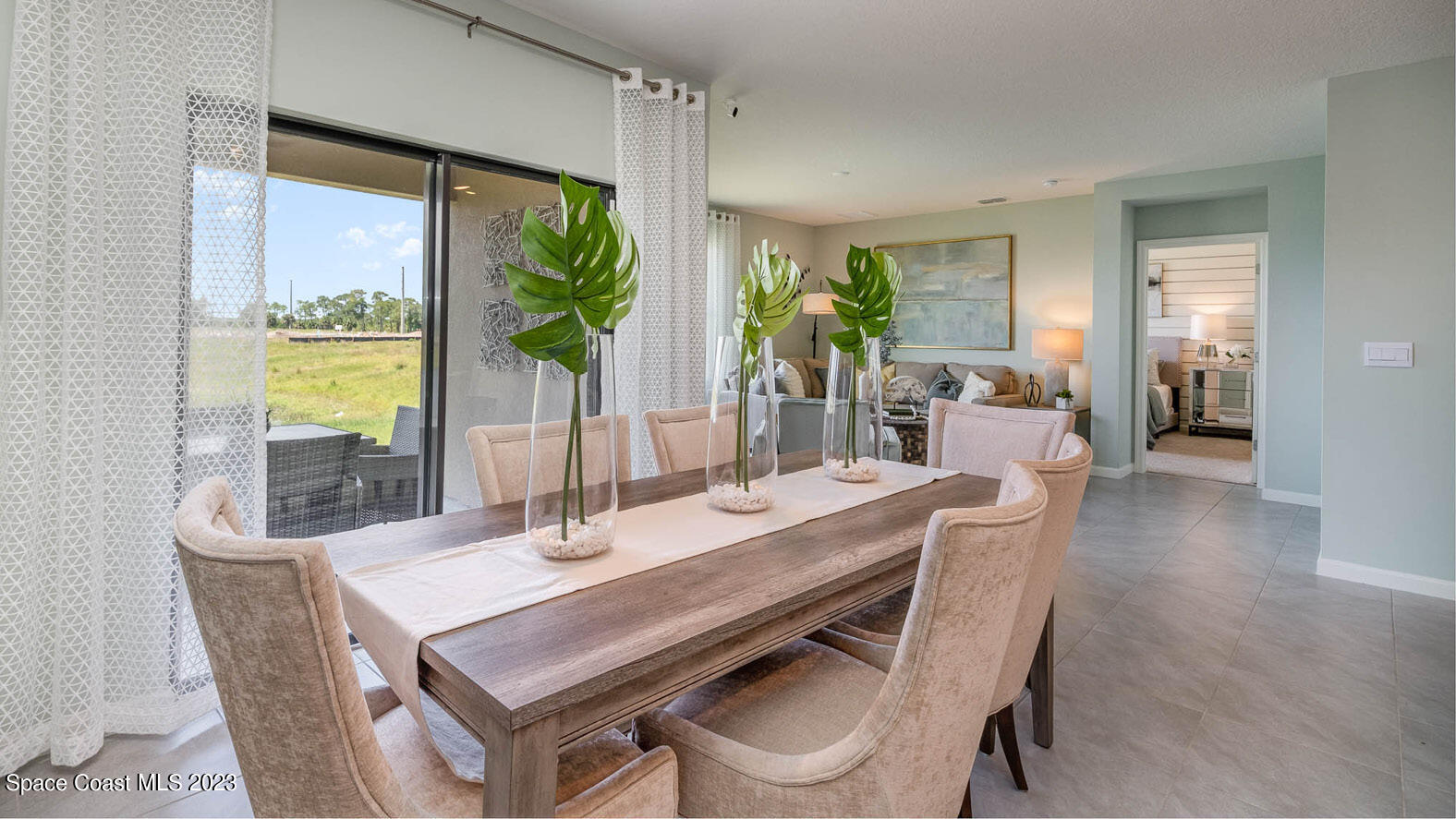4954 Quartz Place Grant-Valkaria, FL 32949 - Photo 7 of 48 a dining room with furniture a potted plant and a chandelier
