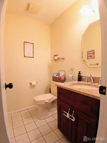 a bathroom with a granite countertop sink a toilet and a mirror